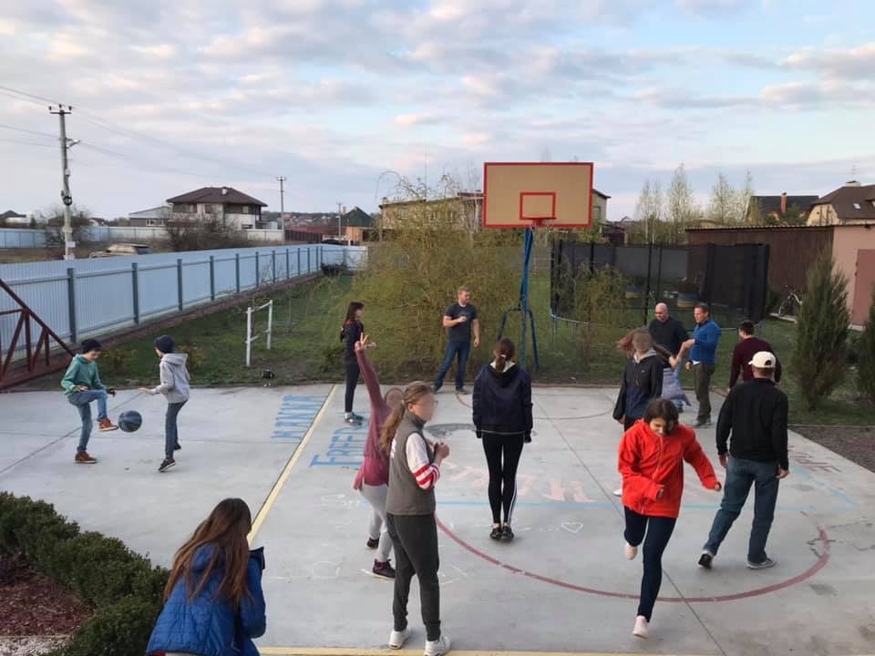 Children standing around a basketball court