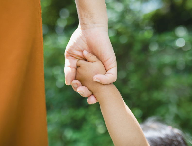 mother holding childs hand