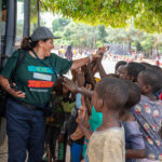 Woman giving high five to young children